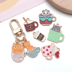 Macro detail of colorful enamel cat coffee cup charms in zinc alloy on white background