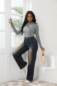 Dettaglio dei jeans a vita alta a gamba larga con lavaggio vintage sulla coscia