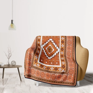 Bohemian geometric flannel blanket draped over a yellow sofa in a minimalist room
