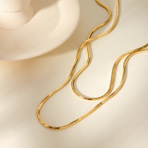 Macro detail of 18K gold plated snake chain necklace with high gloss metal scales