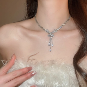 Detail of silver butterfly pendant necklace with zircon fringe worn by a model