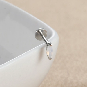 Vue macro d'un clou en opale marquise avec détail de piercing à fond plat vissé argenté