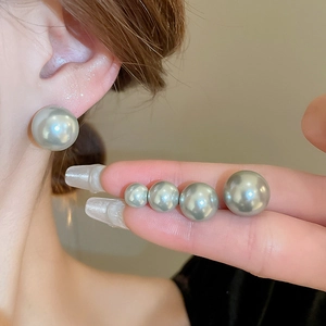 Grey faux pearl geometric earrings shown in different sizes against a hand and ear