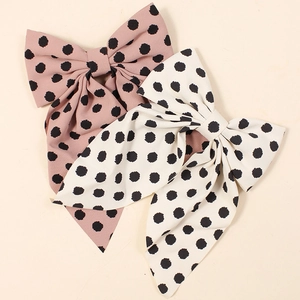 Set of two fabric bow hair clips with polka dots in pink and cream colors