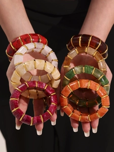 Detail showing colorful resin elastic bracelets with 18k gold plated metal spacers