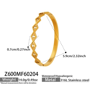 Detail of 316L stainless steel gold geometric bangle with inset white crystals