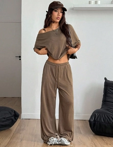 Vista detallada de conjunto marrón para mujer con top de hombros caídos y pantalón ancho