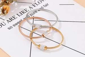 Vue détaillée des bracelets à cylindre en cristal pavé en finitions or, argent et rose