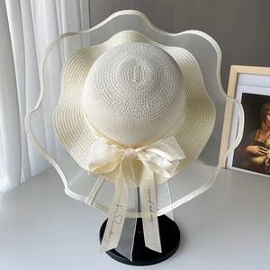Elegant wide brim straw sun hat with lace edge and decorative bow for beach vacations