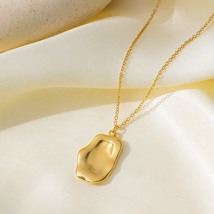 Minimalist 18K gold plated titanium steel necklace with irregular pendant on beige silk