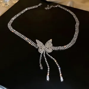 Ras du cou papillon à pompons luxueux avec strass étincelants sur fond noir