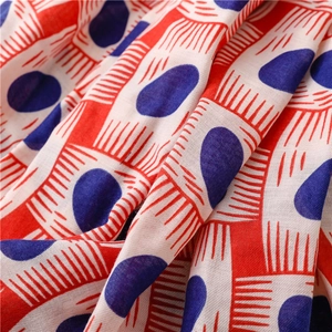Macro detail of red geometric lines and blue ovals on soft woven cotton-linen fabric