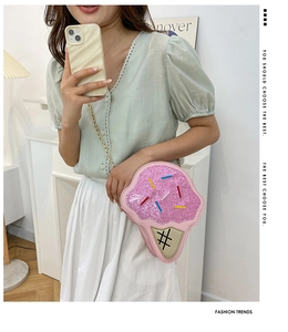Detail of pink glitter ice cream crossbody bag with gold chain strap on a model