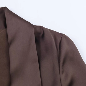 Detail of premium brown satin fabric dress showing shoulder seam and silky texture