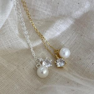 Detailed macro view of gold and silver pearl necklaces with cubic zirconia pendants