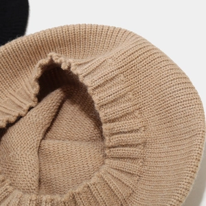 Detail of camel knitted beret showing thick weave texture and ribbed edge craftsmanship