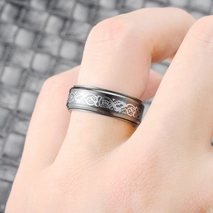 Close-up view of a men's black titanium steel spinner ring with silver dragon pattern