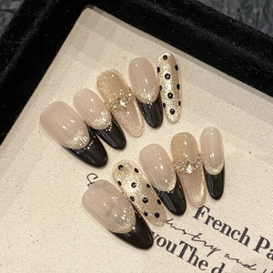 Handmade black and gold cat-eye press-on nails with french tips and rhinestones