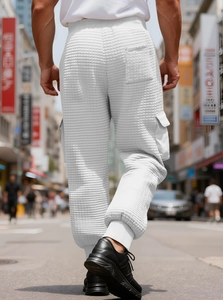 Detail of white waffle texture men's cargo sweatpants with large functional pockets