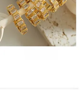 Detailed close-up of gold titanium steel jewelry with channel-set baguette cubic zirconia