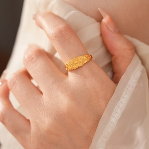 Dettaglio dell'anello vintage in oro con rilievo floreale e tre fiori incisi sul dito