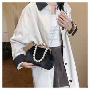 Detail of black plush clasp bag featuring elegant pearl top handles and a long shoulder strap