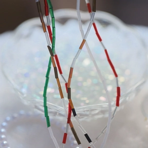 Macro shot of colorful cylindrical Czech glass tube beads arranged in tiered necklaces