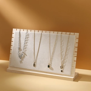 Detailed view of wooden necklace display stand with premium beige velvet lining and jewelry