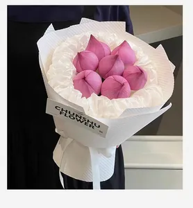 Detail of pink lotus bouquet wrapped in white textured embossed floral packaging paper