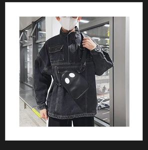 Close-up of a funny ghost pattern PU leather crossbody bag worn with a denim jacket
