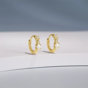 Detail of gold-plated silver huggie hoops featuring kite-shaped opal and clear zircon