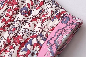 Detail shot of multi-color floral print and quilted fabric texture with fine stitching