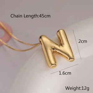 Detailed close-up of golden balloon letter N pendant necklace with dimension specs