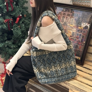 Ethnic plush tote bag featuring blue and beige geometric patterns in a cozy holiday scene