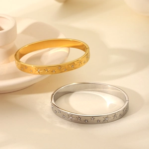 Detail of gold and silver stainless steel star bracelets with inlaid crystals and clasps