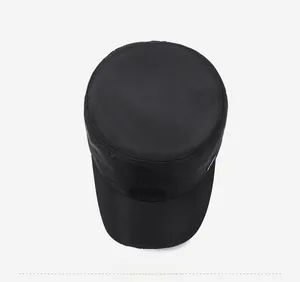 Top down view showing the circular crown of a black flat top military cap for men