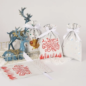 Christmas drawstring gift bags with reindeer, snowflake patterns and white ribbons