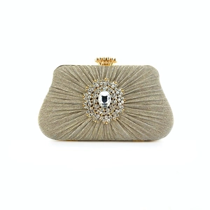 Close-up of pleated gold evening clutch with elegant floral rhinestone embellishment