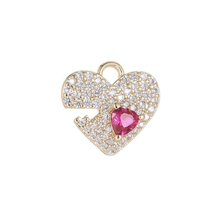 Golden heart pendant with pink gemstone and crystals on white background