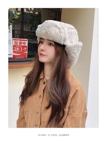 Close-up of thick cream faux fur trapper hat with protective ear flaps for winter warmth