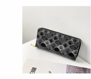 Detail of long zipper wallet with elegant grey scalloped shell pattern and gold metal hardware