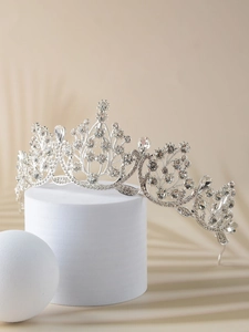 Detailed close-up of a vintage silver bridal crown with intricate crystal and rhinestone floral patterns