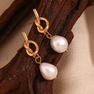 Detail view of 18K gold plated knot earrings featuring white baroque freshwater pearls