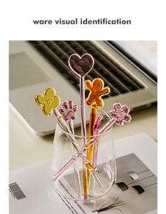 Macro view of assorted glass coffee stirrers with heart and flower shapes in a glass cup