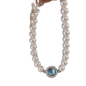 Elegant pearl necklace featuring a blue gemstone center with diamond accents on white