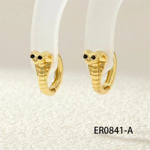 Close-up of gold cobra hoop earrings with black gemstone eyes and textured snake details
