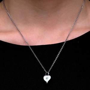 Silver heart cremation pendant necklace with small crystal stone on a female model
