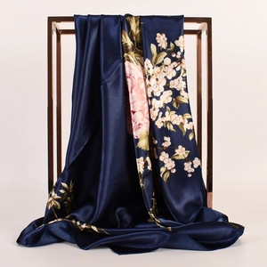 Eleganter dunkelblauer Seidenschal mit Pfingstrosen am roségoldenen Metallrahmen hängend