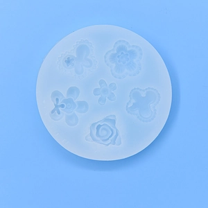 Round silicone baking mold with 6 different floral and butterfly patterns on blue background