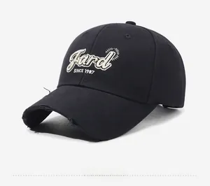 Detail of vintage black baseball cap showing frayed brim and 1987 embroidery
